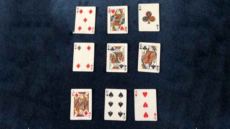 9 playing cards from the Dapper Deck from Vanishing Inc. are used for a mind reading card trick performed on a blue close-up mat